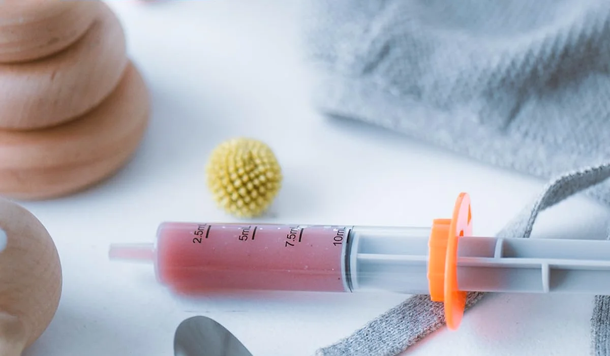 An Ezy Dose oral syringe drawing a dose through a bottle adapter