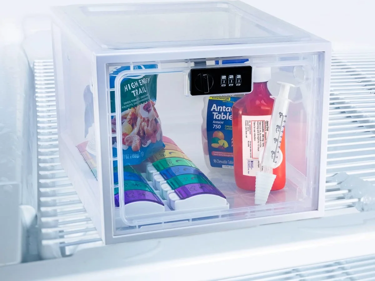The medication lockbox on a refrigerator shelf, bottles inside