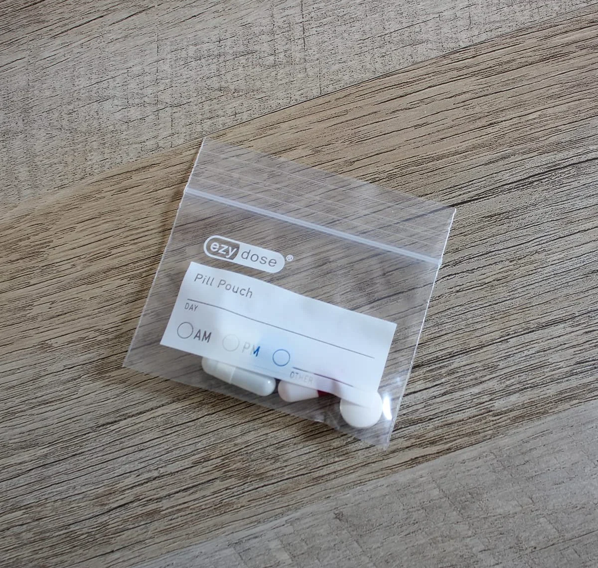 A pill pouch with a day’s tablets, on a wooden table